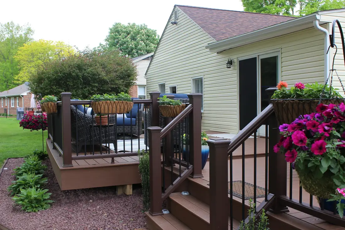 Dark composite deck with black rail and planters — Oasis Custom Decks