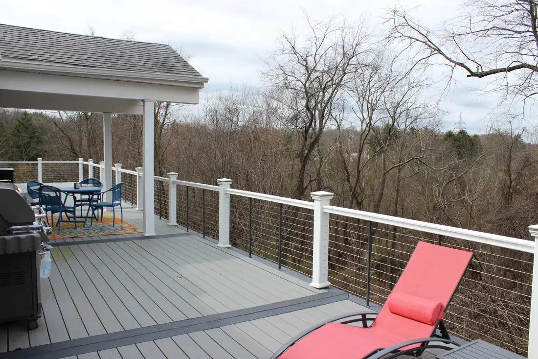 Gray composite deck with red loungers — Oasis Custom Decks
