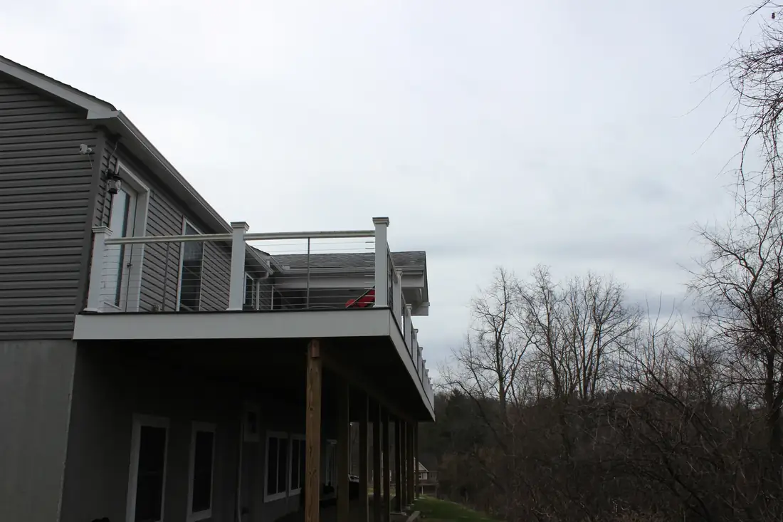 Gray composite, white rail, wooded view — Oasis Custom Decks