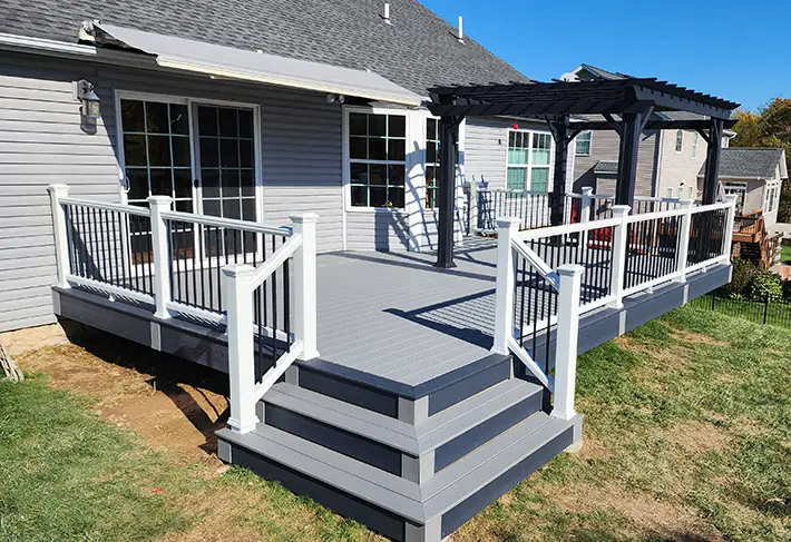 Gray composite with white rail and black pergola — Oasis Custom Decks