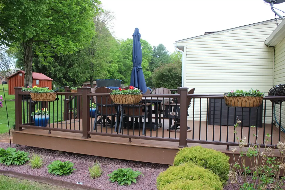Brown composite deck with flower beds — Oasis Custom Decks