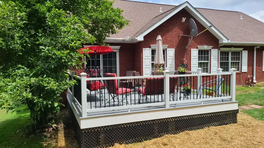Deck with white rail on a brick home — Oasis Custom Decks