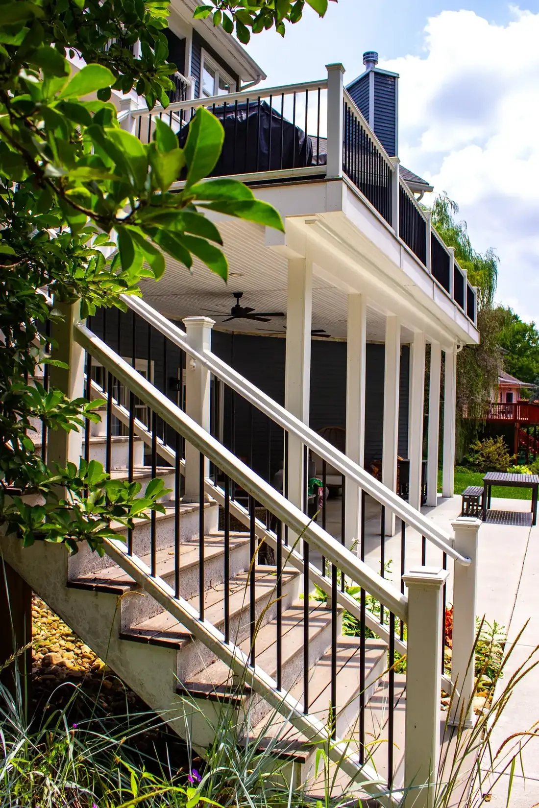 Stair landing with white rail and black balusters — Oasis Custom Decks